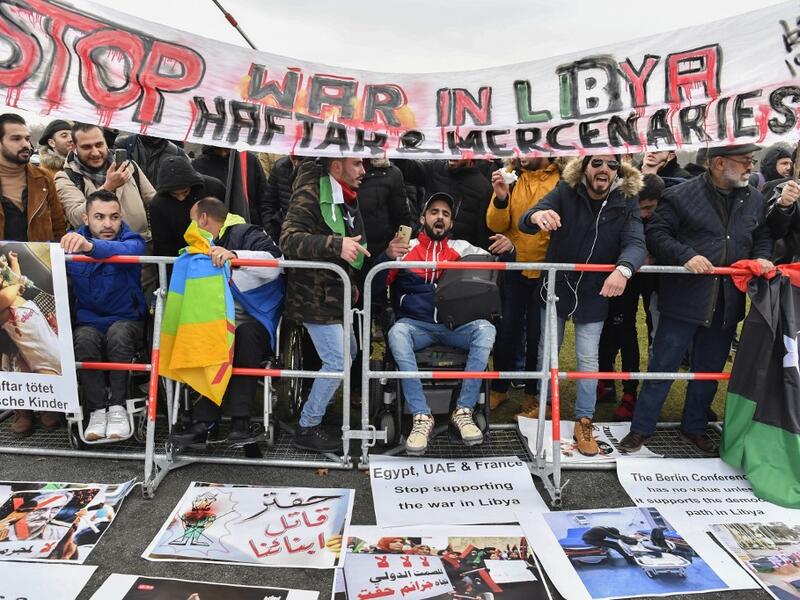 Protesters hold a banner reading "Stop war in Libya, Haftar and mercenaries" during a protest near the chancellery during the Peace summit on Libya at the Chancellery in Berlin on January 19, 2020.  AFP