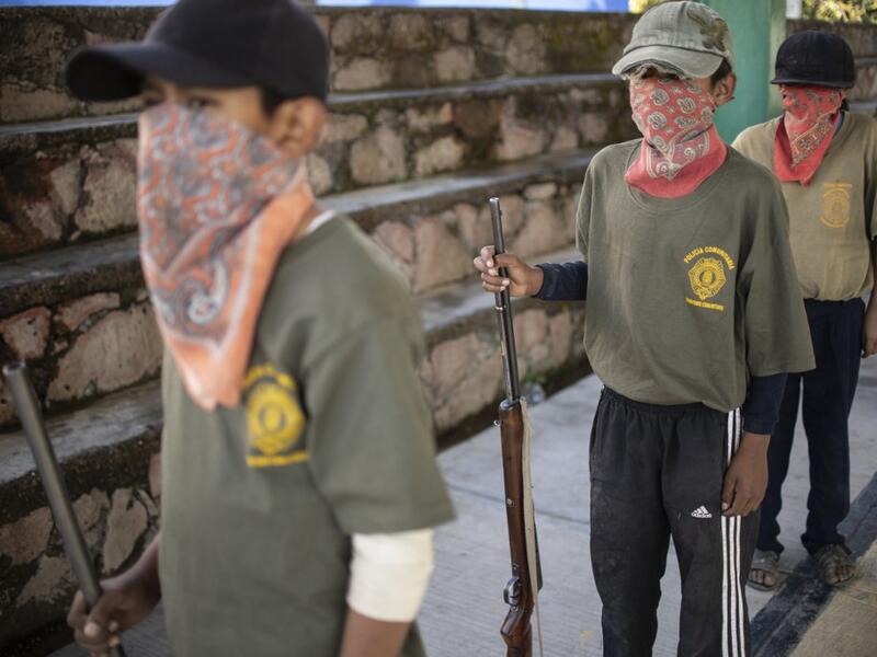 Children line up as thay are tought to use weapons by the Regional Coordinator of Community Authorities (CRAC-PF) community police force at a basketball court in the village of Ayahualtempan, Guerrero State, Mexico, on January 24, 2020. The CRAC-PF vigilante group trains children as young as five so they can protect themselves from drug-related criminal groups operating in the area. Pedro PARDO / AFP