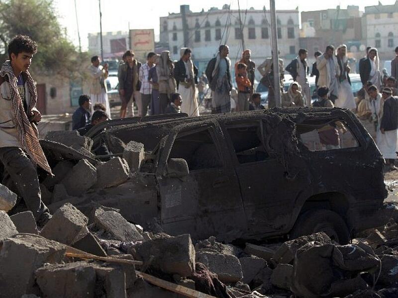 Yemenis stand at the site of a Saudi airstrike against Houthi rebels near Sanaa Airport on March 26, 2015, which killed at least 13 people. (photo credit: AFP/Mohammed Huwais)