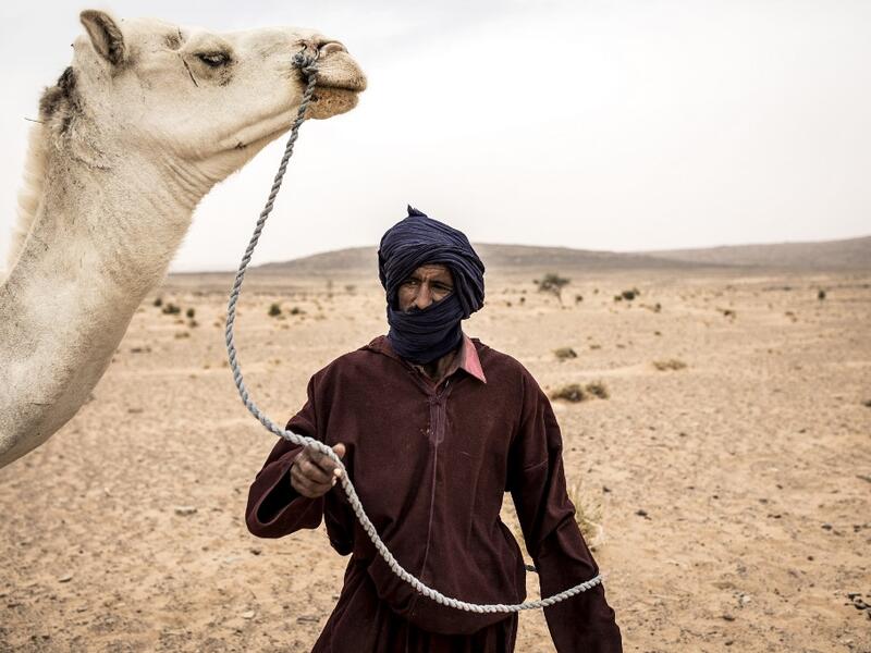 Cheih, from the small Nemadi(hunters) tribe in Eastern Mauritania is seen with a camel in desert between Tichitt to Aratane in Mauritania on January 23, 2020. In the arid West African country of Mauritania, the way of life of the traditional group of hunters known as the Nemadi is slowly disappearing. JOHN WESSELS / AFP