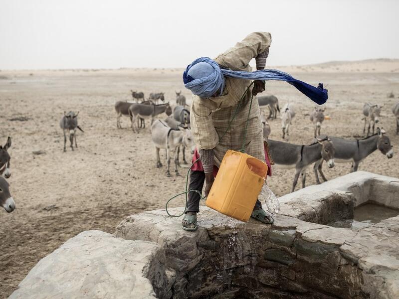 Ahmed(20), from the small Nemadi(hunters) tribe in Eastern Mauritania, pulls water out of one of the few water wells along the caravan route from Tichitt to Aratane in Mauritania on January 25, 2020. In the arid West African country of Mauritania, the way of life of the traditional group of hunters known as the Nemadi is slowly disappearing. JOHN WESSELS / AFP