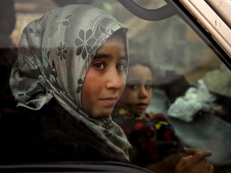 Displaced Syrian girls look on from within a vehicle passing through the town of Hazano in the northern countryside of Idlib, on February 4, 2020, fleeing northwards amid an ongoing regime offensive. A Russian-backed Syrian government offensive against the country's last rebel enclave of Idlib has displaced more than half a million people in two months, according to the United Nations. The wave of displacement, which coincides with a biting winter, is one of the largest since the start of the Syrian war nea