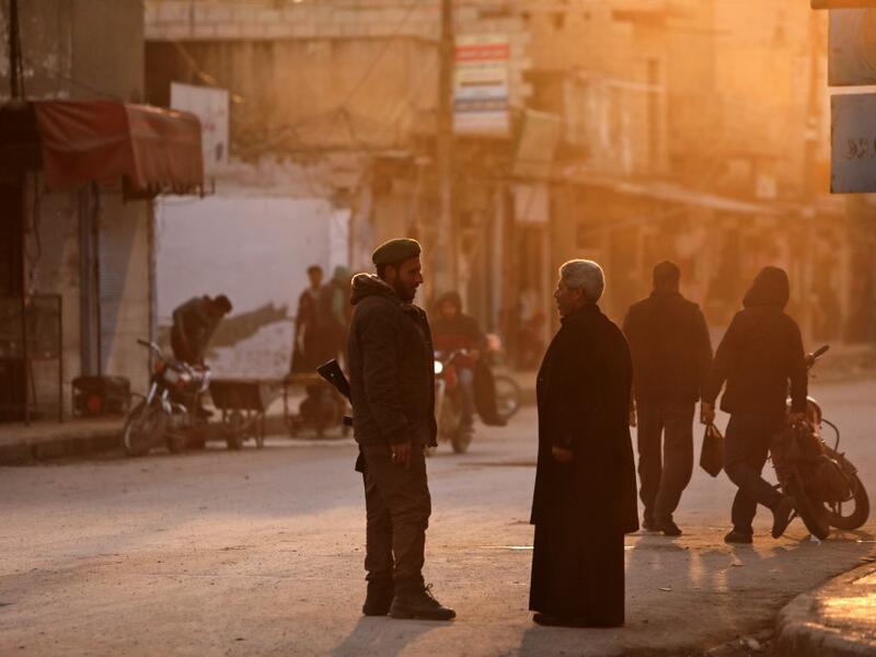 A man speaks with a Turkish-backed Syrian fighter in the northern Syrian town of Tal Abyad by the border with Turkey on February 4, 2020. Bakr ALKASEM / AFP