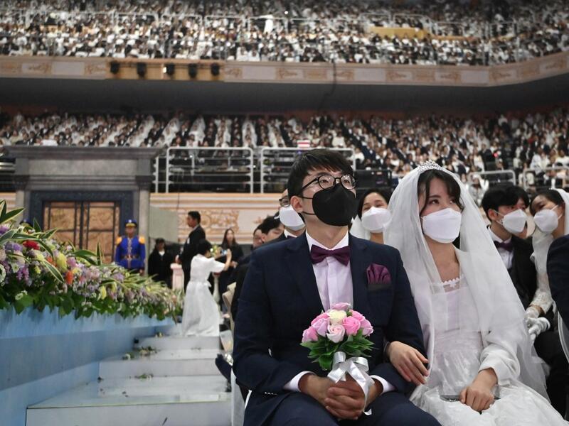 Couples wearing protective face masks attend a mass wedding ceremony organised by the Unification Church at Cheongshim Peace World Center in Gapyeong on February 7, 2020. South Korea has confirmed 24 cases of the SARS-like virus so far and placed nearly 260 people in quarantine for detailed checks amid growing public alarm. Jung Yeon-je / AFP