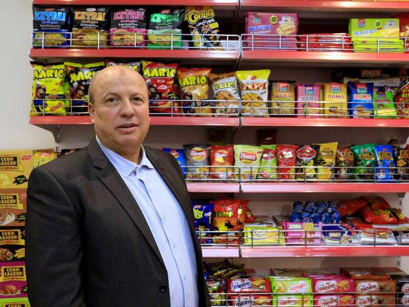 Wael al-Wadiya, chairman of Sarayo Alwadiya company, poses for a photo in front of some of the products his factory produces in Gaza City on February 4, 2020. Israel permits some vegetables and clothing to be sold abroad but not processed food.  EMMANUEL DUNAND / AFP