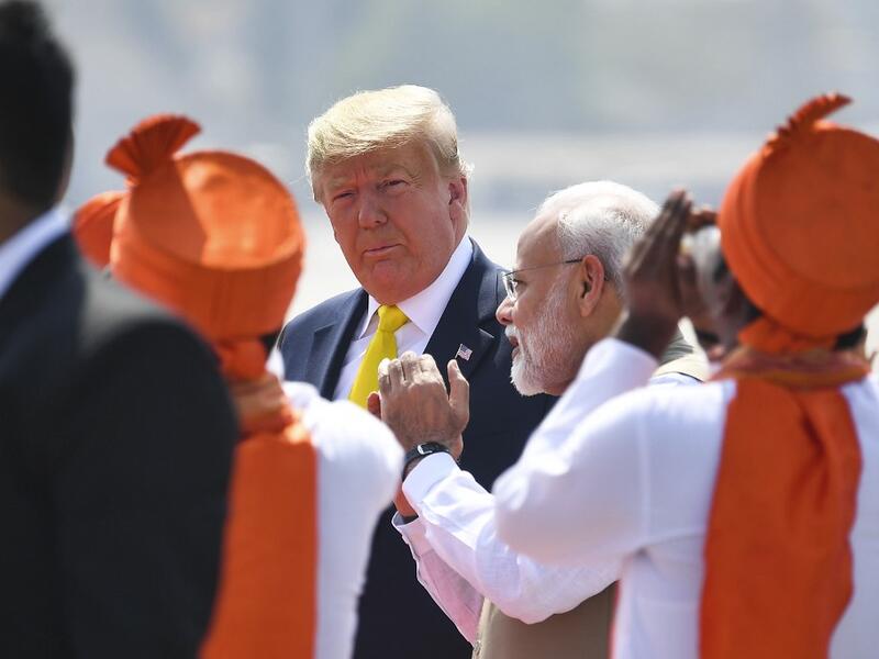 India's Prime Minister Narendra Modi (R) speaks with US President Donald Trump (C) upon his arrival at Sardar Vallabhbhai Patel International Airport in Ahmedabad on February 24, 2020. MANDEL NGAN / AFP