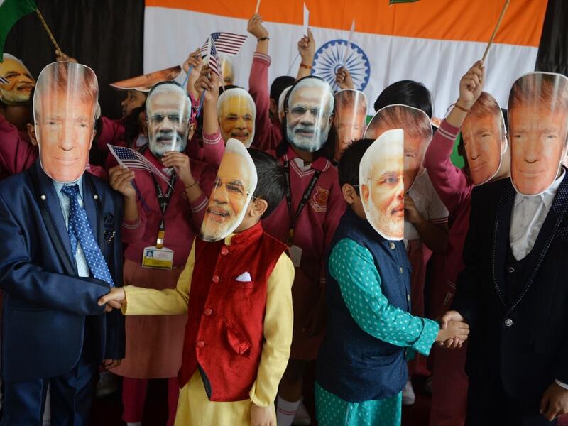Indian school children wearing masks of Indian Prime Minister Narendra Modi and US President Donald Trump pose for a picture while shaking hands at Bright Academy school in Siliguri on February 24, 2020, on the occasion of Trump's first official visit to India. DIPTENDU DUTTA / AFP