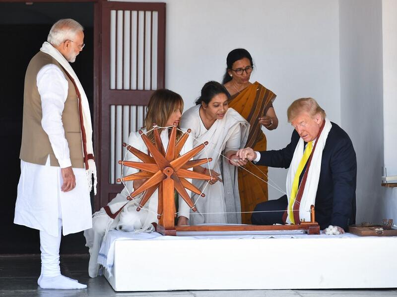 US President Donald Trump (R) holds a string while checking a charkha, or spinning wheel, as First Lady Melania Trump (2L) and India's Prime Minister Narendra Modi (L) look on during their visit at the Gandhi Ashram in Ahmedabad on February 24, 2020. Mandel NGAN / AFP