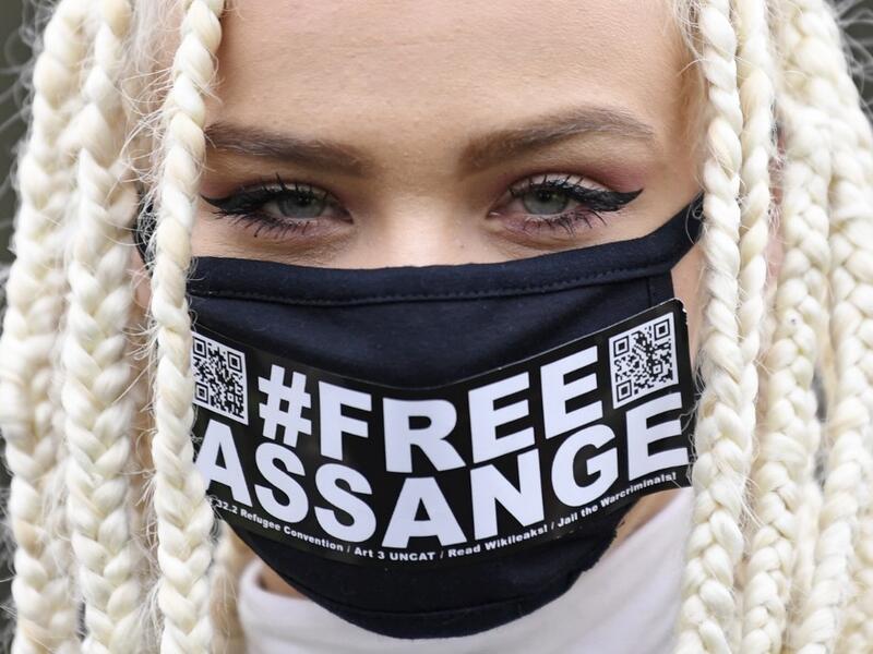 Nina from Amsterdam, a supporter of WikiLeaks founder Julian Assange, wears a face mask called for Assange's freedom as she poses for a photograph outside Woolwich Crown Court in southeast London on February 24, 2020, on the day of the opening of the full hearing into a US request for Assange's extradition. A British court on February 24 starts hearing Washington's extradition request for WikiLeaks founder Julian Assange in a test case of media freedoms in the digital age and the global limits of US justice