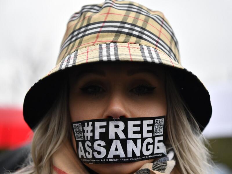 A supporter of WikiLeaks founder Julian Assange wearing tape on her mouth calling for his freedom  (AFP)
