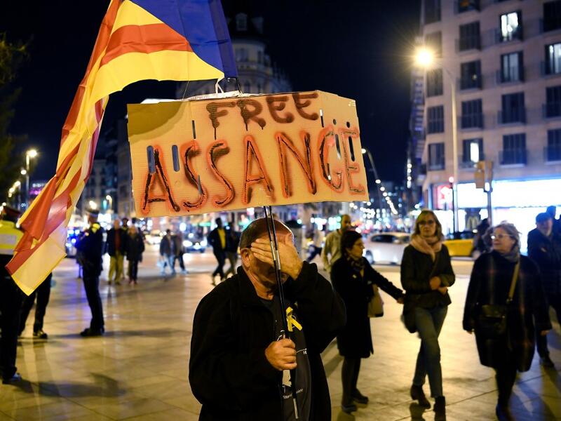A demonstrator covers his face as he takes part in a protest called by Catalan National Assembly (ANC) under the motto "Journalism is not a crime" to support WikiLeaks founder Julian Assange in Barcelona on February 24, 2020. A British court today starts hearing Washington's extradition request for WikiLeaks founder Julian Assange in a test case of media freedoms in the digital age and the global limits of US justice. LLUIS GENE / AFP