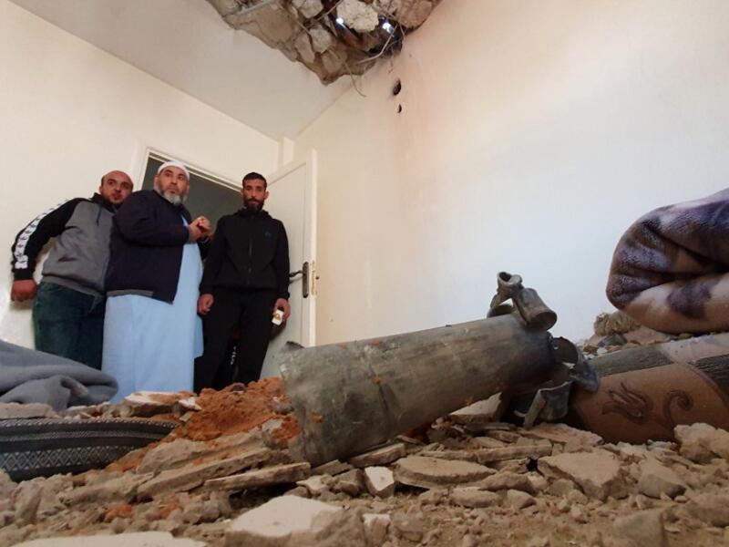 This picture taken on February 28, 2020 shows people inspecting the damage inside a building following a rocket attack by forces loyal to eastern Libyan strongman Khalifa Haftar, at a residential area in the government of national accord (GNA)-held capital Tripoli. AFP/File