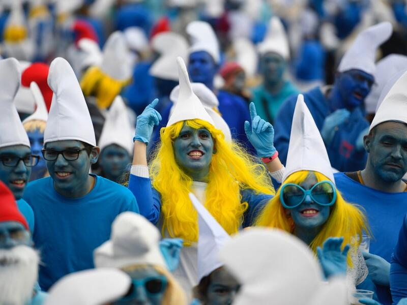 People dressed as Smurfs ('Schtroumpfs' in French), a Belgian comic franchise centered on a fictional colony of small, blue, human-like creatures who live in mushroom-shaped houses in the forest, attend a world record gathering of Smurfs on March 7, 2020, in Landerneau, western France. Damien MEYER / AFP