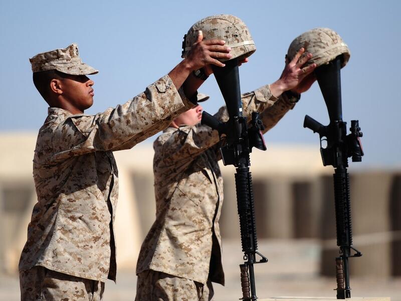 In this file photo taken on January 30, 2010, US Marines from 1st Battalion, 6th regiment, Charlie company prepare memorials for Sergeant Daniel Angus and Lance Corporal Zachary Smith, who were killed on the battlefield on January 24, in Fiddler's Green camp, on the outskirts of Marjah in central Helmand. American forces have started pulling out of two bases in Afghanistan, a US official said on March 10, 2020 the day peace talks between Kabul and the Taliban were due to start despite widespread violence an