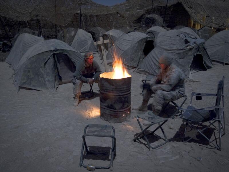 In this file photo taken on December 19, 2010, US soldiers from Alpha Troop 1-75 Cavalry 2nd Brigade 101st Airborne Devision warm themselves around a bonfire at the Sabloghay Camp in Zari district of Kandahar province. American forces have started pulling out of two bases in Afghanistan, a US official said on March 10, 2020 the day peace talks between Kabul and the Taliban were due to start despite widespread violence and a political crisis. The United States is keen to end its longest-ever conflict, and un
