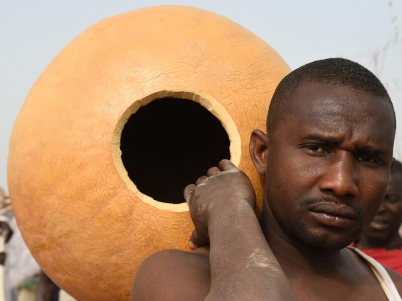 A fisherman carries a calabash and prepares to attend the Argungu fishing and cultural festival at Argungu Town, Kebbi State, in northwest Nigeria, on March 14, 2020. Argungu fishing and cultural festival is one of the oldest and most widely attended festivals in the country dating back many generations, featuring series of water competitions and traditional games. The festival returned after 10 years suspension due to insecurity in northwest Nigeria. PIUS UTOMI EKPEI / AFP