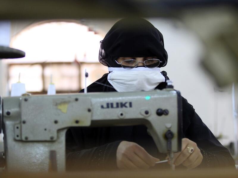 A Yemeni woman makes face masks at a textile factory in the capital Sanaa on March 16, 2020. More than a decade after it shut down, 20 women have brought back to life Yemen's oldest industrial factory to manufacture what could save many lives amid a global pandemic: masks. Mohammed HUWAIS / AFP