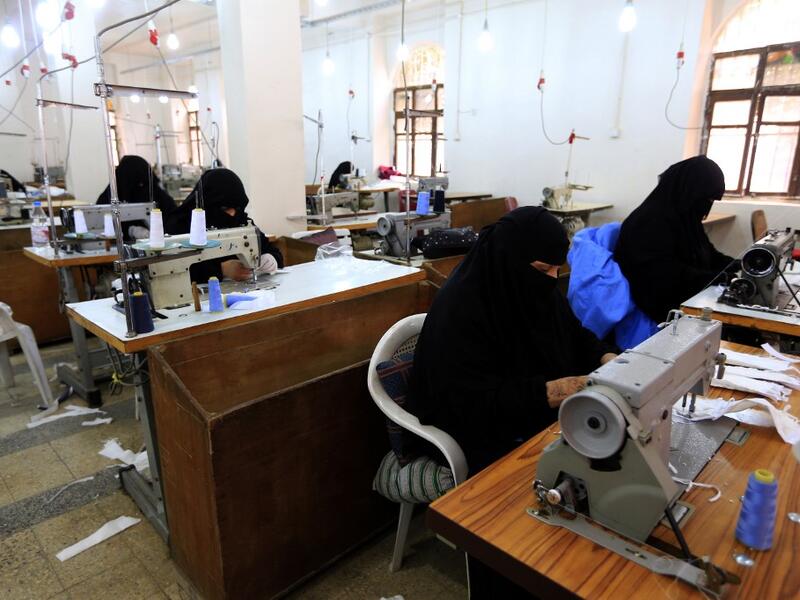 Yemeni women make face masks at a textile factory in the capital Sanaa on March 16, 2020. More than a decade after it shut down, 20 women have brought back to life Yemen's oldest industrial factory to manufacture what could save many lives amid a global pandemic: masks. Mohammed HUWAIS / AFP