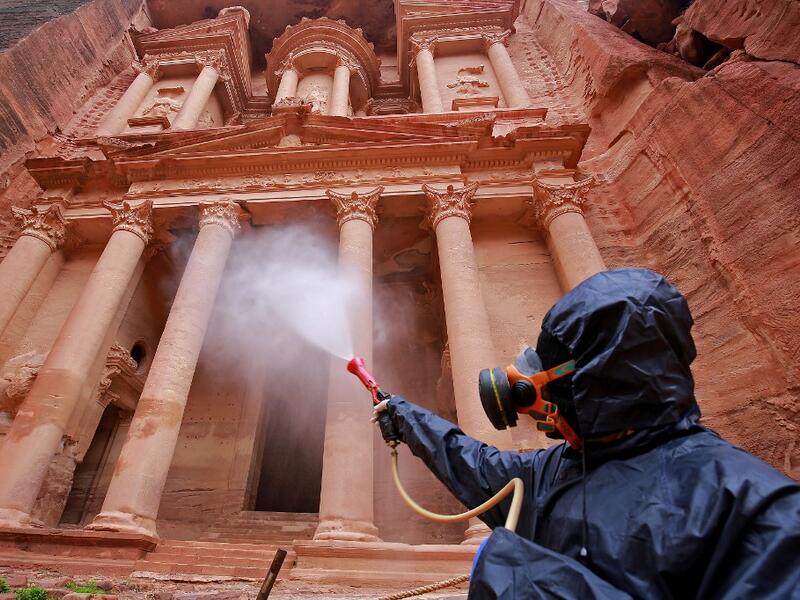 A labourer sprays disinfectant in Jordan's archaeological city of Petra south of the capital Amman on March 17, 2020, to prevent the spread of COVID-19. Khalil MAZRAAWI / afp