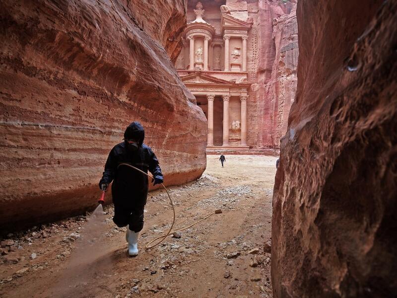 A labourer sprays disinfectant in Jordan's archaeological city of Petra south of the capital Amman on March 17, 2020, to prevent the spread of COVID-19. Khalil MAZRAAWI / afp
