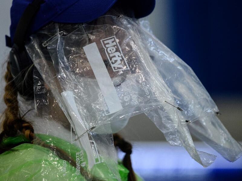 A passenger wears a face mask and plastic food bags on her face as a precautionary measure against the COVID-19 coronavirus after landing at Hong Kong’s international airport on March 19, 2020. On March 18, Hong Kong authorities began ordering all arrivals from overseas to wear electronic bracelets, connected to an app to mark your location, and two weeks self-quarantine. ANTHONY WALLACE / AFP