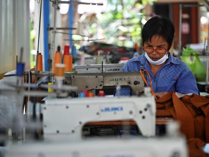 A Buddhist devotee sews face masks made from fabric derived from recycled plastic bottles, amid concerns over the spread of the COVID-19 coronavirus, at Wat Chak Daeng Buddhist temple in Samut Prakan on March 23, 2020. The plastic wastes are sent to a separate recycling facility processing it into thread materials and woven as special fabric for monks. Lillian SUWANRUMPHA / AFP