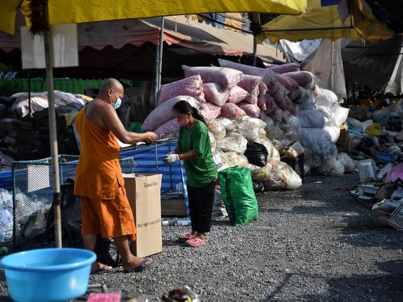 A Buddhist monk sorts salvaged plastic bottles to be recycled into monks’robes and face masks, amid concerns over the spread of the COVID-19 coronavirus, at Wat Chak Daeng Buddhist temple in Samut Prakan on March 23, 2020. The plastic wastes are sent to a separate recycling facility processing it into thread materials and woven as special fabric for monks. Lillian SUWANRUMPHA / AFP