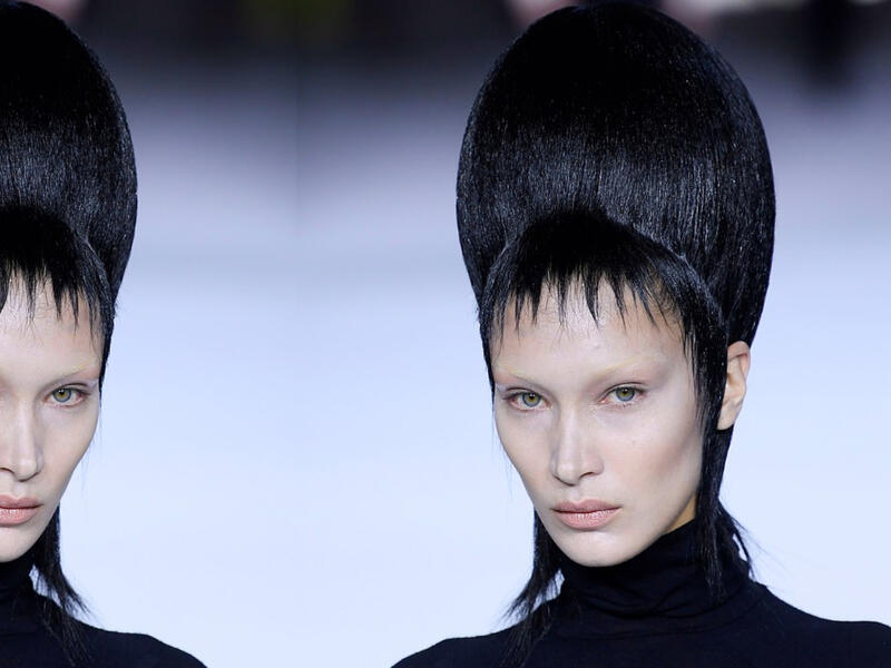 Bella took to the runway in a black form-fitting polo neck and satin pleated culottes