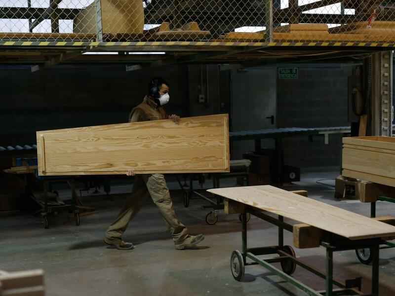 An employee works at the Eurocoffin coffins factory in Barcelona on April 3, 2020. More than 900 people died in Spain over the past 24 hours for the second day running, government figures showed, although the rate of new infections and deaths continued to slow. Spain has the world's second-highest death toll after Italy with the virus so far claiming 10,935 lives from 117,710 confirmed cases.  PAU BARRENA / AFP