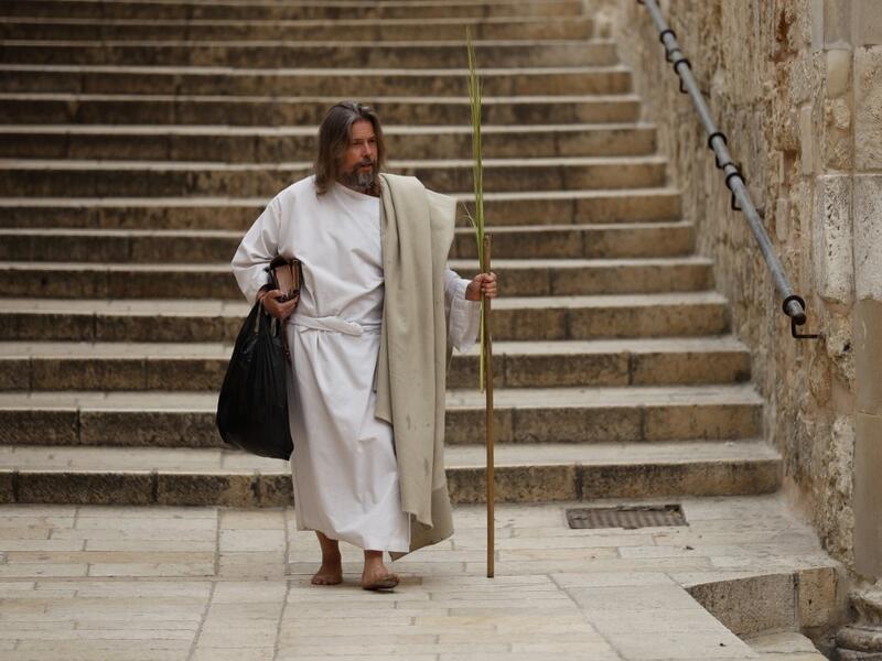 A worshipper arrives to pray outside the closed door of the Holy Sepulchre Church on Palm Sunday in Jerusalem's Old City amid movement restrictions due to the COVID-19 coronavirus pandemic, on April 5 2020. Ahmad GHARABLI / AFP