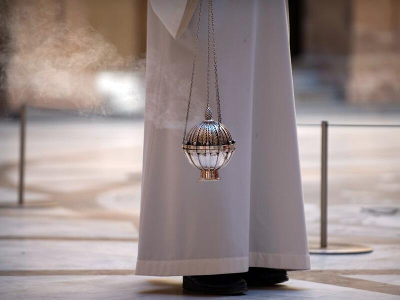 A priest holds an incense burner during the Palm Sunday Mass on April 5, 2020, at the Santa Maria de Montserrat abbey in Monistrol de Montserrat, during a national lockdown to prevent the spread of the COVID-19 disease. Spain saw its third consecutive daily decline in the number of people dying from the coronavirus pandemic as the country recorded another 674 fatalities today. Josep LAGO / AFP