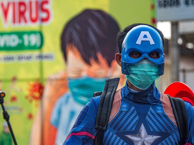 An Indonesian police officer wearing a superhero costume on the street disinfects motorists' vehicles in Pasuruan, East Java on April 9, 2020, amid concert to the COVID-19 coronavirus. JUNI KRISWANTO / AFP
