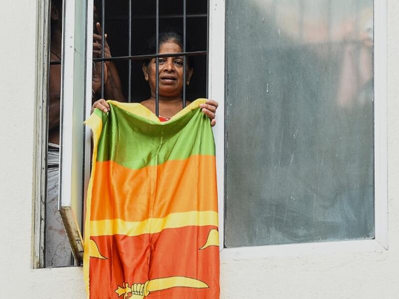 Residents watch from their flat's window a music band formed by Sri Lankan Navy personnel as they play outside a housing complex during a government-imposed nationwide lockdown as a preventive measure against the COVID-19 coronavirus, in Colombo on April 9, 2020. ISHARA S. KODIKARA / AFP