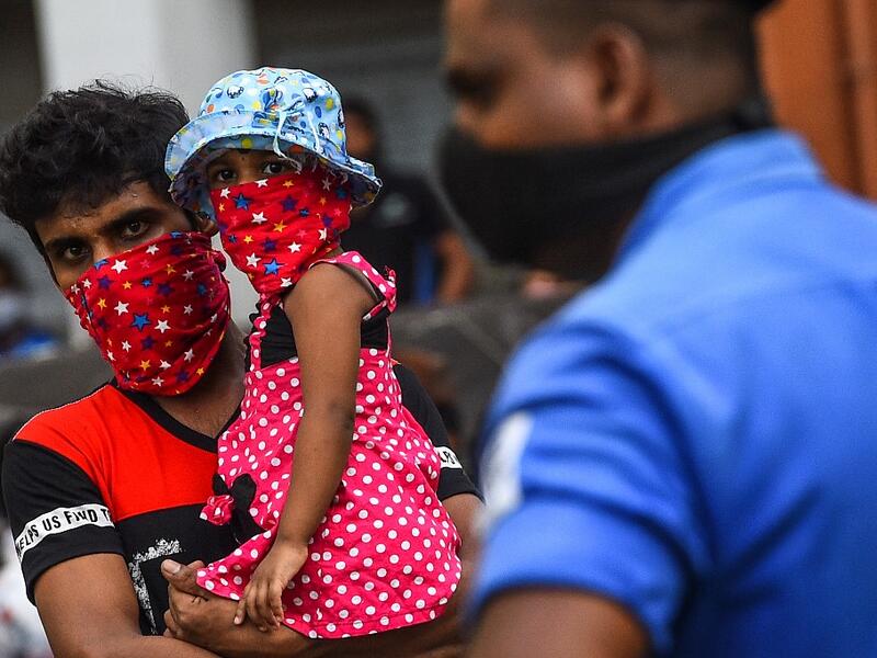 Residents watch a music band formed by Sri Lankan Navy personnel as they play outside a housing complex during a government-imposed nationwide lockdown as a preventive measure against the COVID-19 coronavirus, in Colombo on April 9, 2020. ISHARA S. KODIKARA / AFP