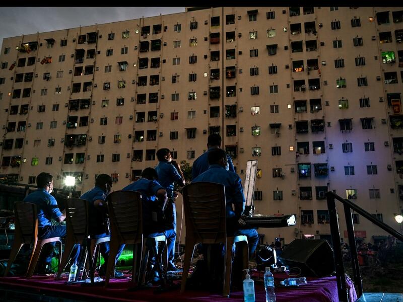 A music band formed by Sri Lankan Navy personnel plays outside a housing complex during a government-imposed nationwide lockdown as a preventive measure against the COVID-19 coronavirus, in Colombo on April 9, 2020. ISHARA S. KODIKARA / AFP