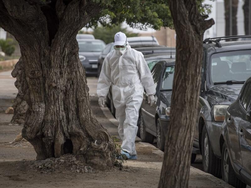 A Moroccan health worker wearing a protective outfit against the novel coronavirus walks in an empty street in the capital Rabat on April 12, 2020. FADEL SENNA / AFP