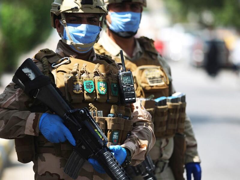 Iraqi soldiers stand at a checkpoint in the Adhamiya district of Baghdad on April 13, 2020 as Iraq imposed a curfew during the coronavirus COVID-19 pandemic. AHMAD AL-RUBAYE / AFP