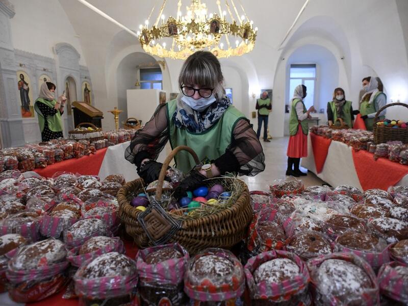 An Orthodox volunteer inspects traditional cakes and eggs before of blessing to be distributed to people in need, on the eve of the Orthodox Easter in Moscow on April 18, 2020, during a strict lockdown in Russia to stop the spread of COVID-19, caused by the novel coronavirus. All church in Moscow were closed to believers and remained open only for priests and personal. Kirill KUDRYAVTSEV / AFP