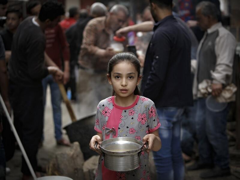 A Palestinian girl carries a portion of soup, given out to poor families, during the Islamic holy month of Ramadan in Gaza City on April 24, 2020, amid the COVID-19 coronavirus pandemic. Mohammed ABED / AFP