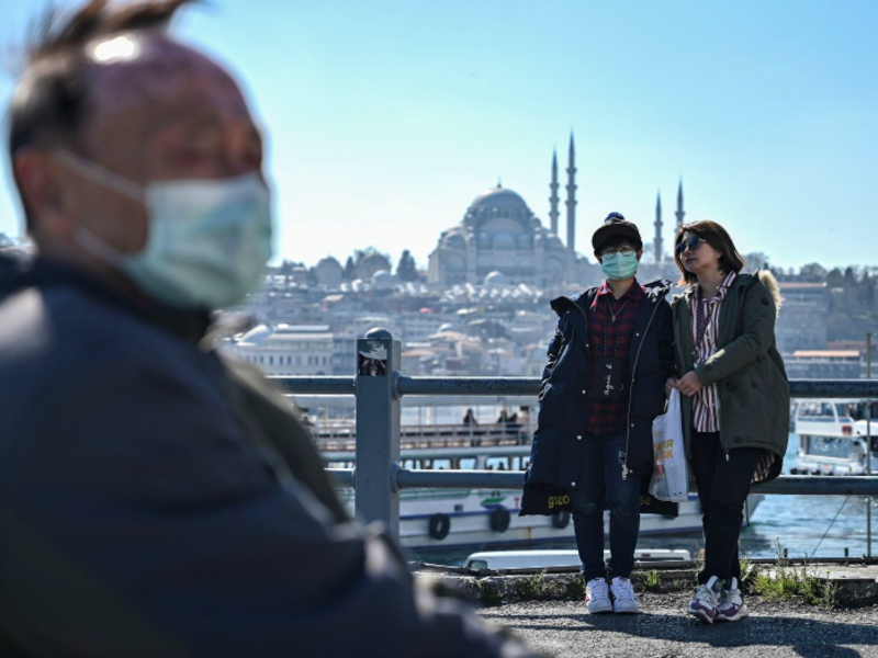 Tourists with facemasks at the Istanbul’s Galata Bridge, 13 March 2020 (AFP Photo)