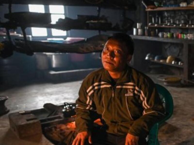 This photo taken on February 8, 2020 shows Tonyei Phawng, king of the Konyak tribe, talking to AFP during an interview inside his home in Longwa village in Myanmar's Sagaing region, near the border with India. The king of the Konyak tribe sleeps in Myanmar, but eats in India -- his house, village and people divided by a mountain border which serves as a vulnerable lifeline now severed by a coronavirus lockdown.  Ye Aung THU / AFP