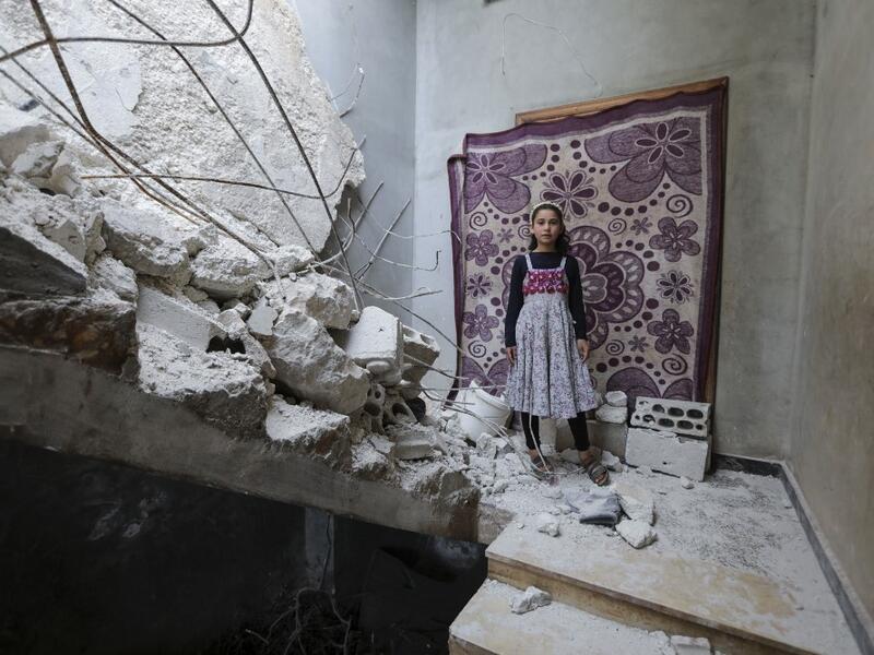 A Syrian girl whose family decided to return home for fear of the COVID-19 pandemic in packed camps for the internally displaced, poses for a picture amid the rubble in her damaged house in al-Nayrab, a village ravaged by pro-government forces bombardment near the M4 strategic highway, in Syria's northwestern Idlib province, on May 3, 2020. Bakr ALKASEM / AFP