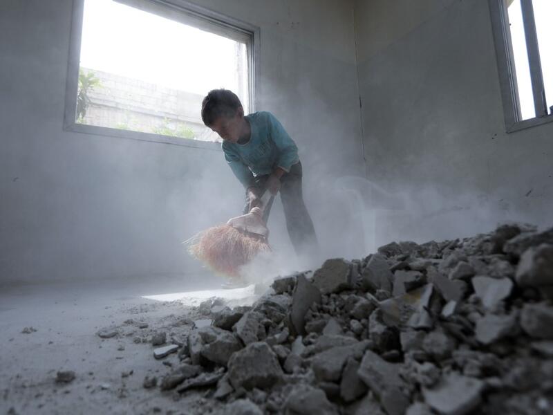 A Syrian youth whose family decided to return home for fear of the COVID-19 pandemic in packed camps for the internally displaced, cleans the rubble from a room in his house in al-Nayrab, a village ravaged by pro-government forces bombardment near the M4 strategic highway, in Syria's northwestern Idlib province, on May 3, 2020. Bakr ALKASEM / AFP