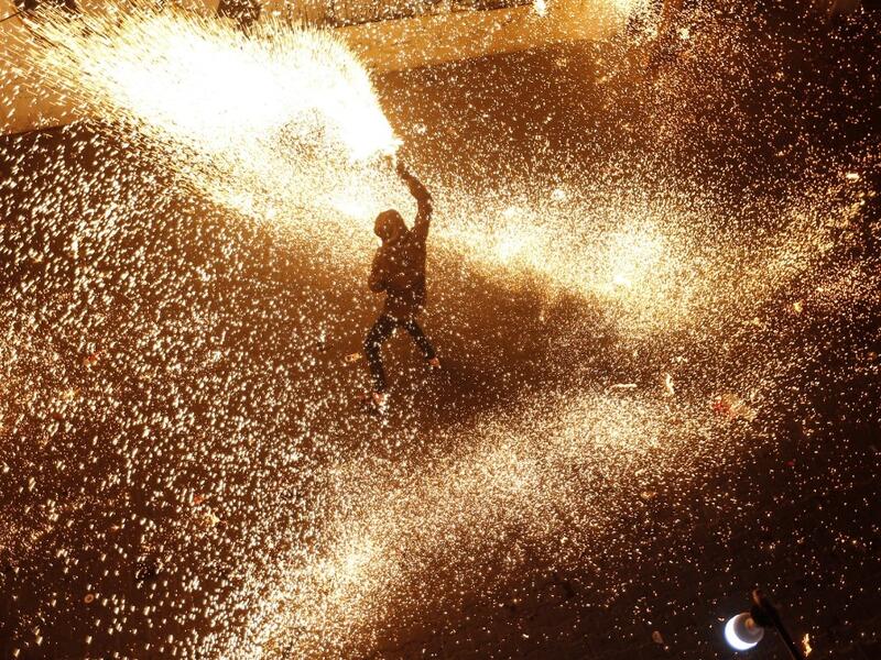 A Palestinian youth swings a homemade sparkler firework as people celebrate on a night of the Muslim holy month of Ramadan in Rafah refugee camp, in the southern Gaza Strip, on May 4, 2020. MAHMUD HAMS / AFP