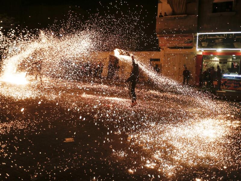 A Palestinian youth swings a homemade sparkler firework as people celebrate on a night of the Muslim holy month of Ramadan in Rafah refugee camp, in the southern Gaza Strip, on May 4, 2020. MAHMUD HAMS / AFP