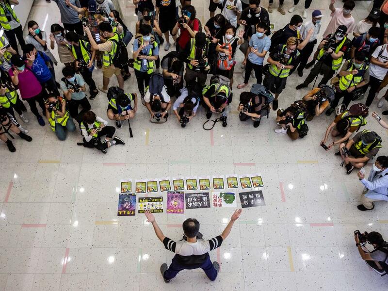 Journalists watch a pro-democracy demonstrator protests calling for the city's independence in Hong Kong on May 10, 2020. ISAAC LAWRENCE / AFP