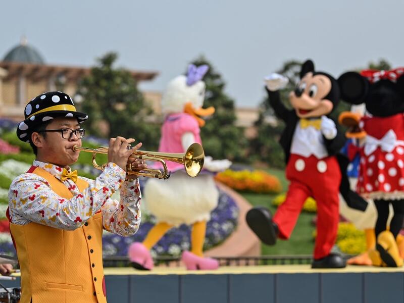 A musician performs during the reopening of the Disneyland amusement park in Shanghai on May 11, 2020. Disneyland Shanghai reopened on May 11 to the public after being closed since January due to the COVID-19 coronavirus outbreak. Hector RETAMAL / AFP