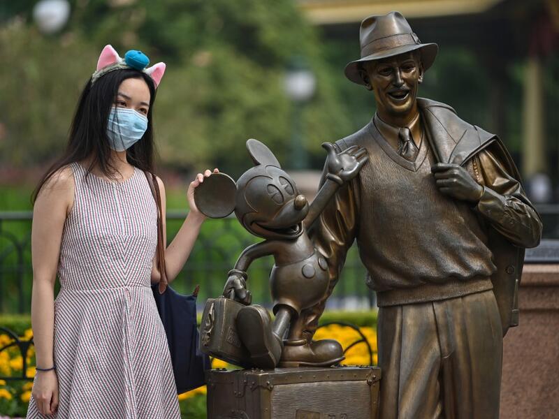 A woman wearing a face masks visits the Disneyland amusement park in Shanghai on May 11, 2020. Disneyland Shanghai reopened on May 11 to the public after being closed since January due to the COVID-19 coronavirus outbreak. Hector RETAMAL / AFP