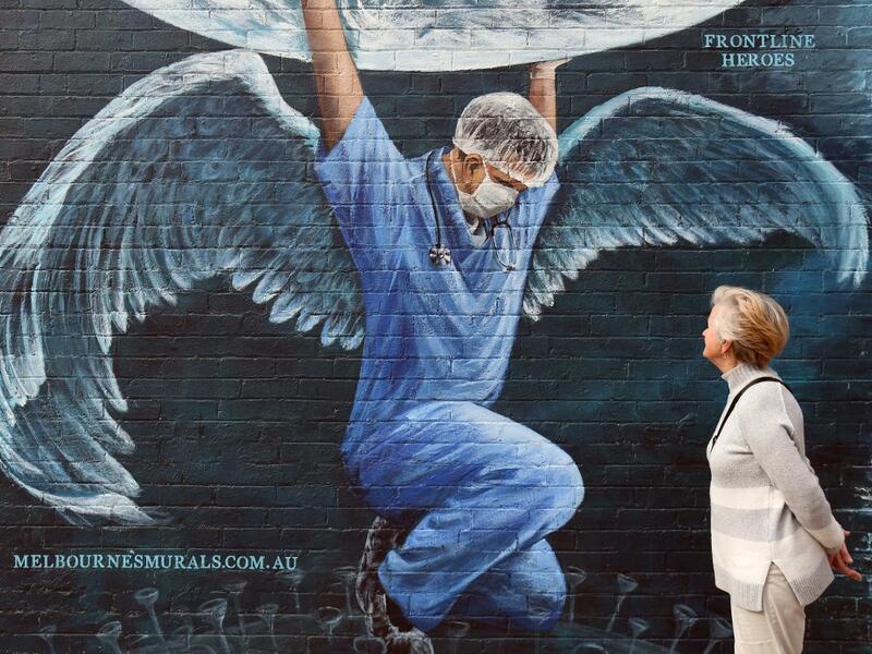 A woman looks at a mural of a health worker with wings holding a globe on International Nurses Day in Melbourne on May 12, 2020. As frontline hospital staff are constantly facing the risks from the COVID-19 coronavirus outbreak, the world is marking International Nurses Day, celebrated around the world every May 12, the anniversary of Florence Nightingale's birth. William WEST / AFP