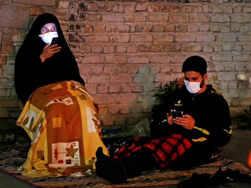 Iranians wearing face masks against the Covid-19 coronavirus attends Laylat al-Qadr prayers, one of the holiest nights during the Muslim fasting month of Ramadan, outside a mosque in the Tehran, on May 13, 2020. ATTA KENARE / AFP
